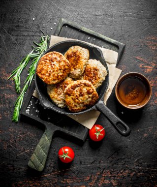 Biberiye ve domates ile kesme Tahtası üzerinde tavada Pirzola. Rustik arka planda