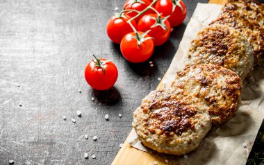 Domatesli kağıt üzerinde pirzola. Koyu rustik arka plan üzerinde