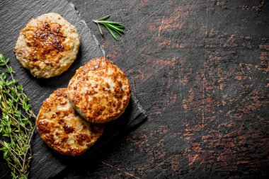 Kekik li siyah taş tahta üzerinde pirzola. Koyu rustik arka plan üzerinde