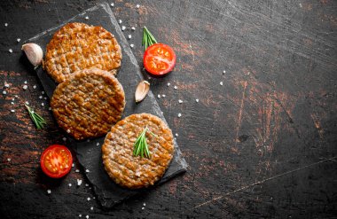 Sarımsak ve dilimlenmiş domates ile pirzola. Koyu rustik arka plan üzerinde