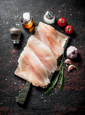 Baharat, biberiye, sarımsak ve yağ ile bir kesme Tahtası üzerinde Balık fileto. Koyu rustik arka plan üzerinde