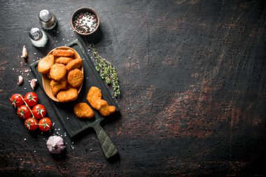Kiraz domates, baharat ve sarımsak karanfil ile Tavuk nuggets. Koyu rustik arka plan üzerinde