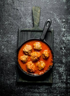 Kesme Tahtası üzerinde tavada et topları. Siyah rustik arka plan üzerinde