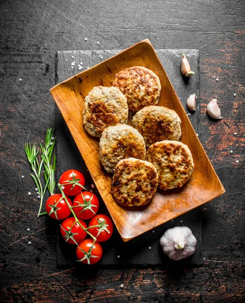 Cutlets Wooden Plate Garlic Rosemary Tomatoes Branch Dark Rustic Background — Stock Photo, Image