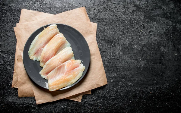 皿の上の魚のフィレット 黒い素朴な背景に — ストック写真