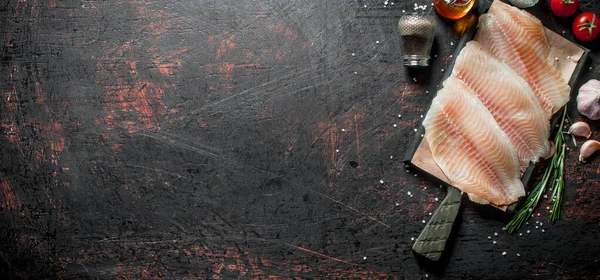 ローズマリー ニンニク スパイスのまな板上の魚の切り身 暗い素朴な背景に — ストック写真