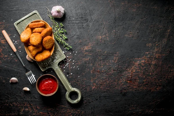 stock image Chicken nuggets with garlic, tomato sauce and thyme. On dark rustic background