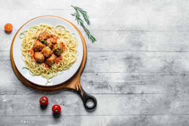 Biberiye ve domates bir tabak üzerinde et topları ile Spagetti. Ahşap arka planda