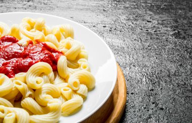 Domates soslu makarna. Siyah rustik arka plan üzerinde