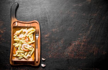 Çatallı bir tabakta karidesli makarna. Rustik arka planda