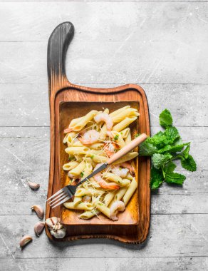 Karides, nane yaprağı ve sarımsak dilimleri ile Makarna. Beyaz ahşap arka plan üzerinde