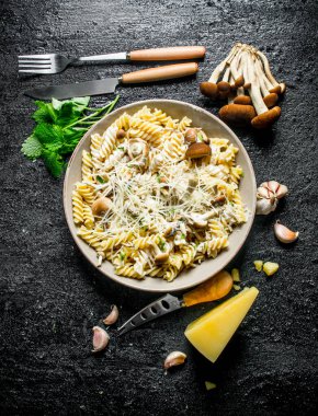 Mantar, nane yaprağı ve Parmesan ile Fusilli makarna. Siyah rustik arka plan üzerinde