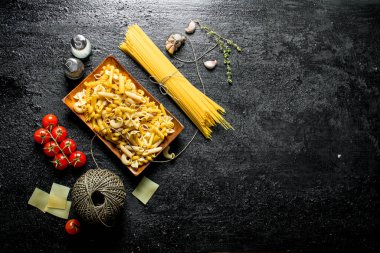 Domuz, kekik, domates ile çiğ hamur farklı. Siyah rustik arka plan üzerinde