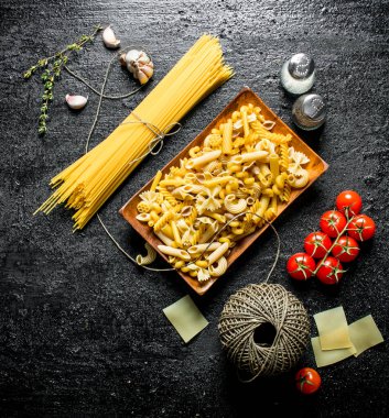 Domuz, kekik, domates ile çiğ hamur farklı. Siyah rustik arka plan üzerinde