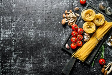 Mantar, domates ve baharat ile ham tagliatelle ve spagetti. Rustik arka planda