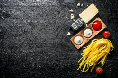 Farklı soslar ve Parmesan ile çiğ ev yapımı makarna. Siyah rustik arka plan üzerinde