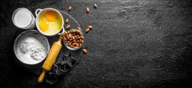 Süt, yumurta ve badem ile un. Siyah rustik arka plan üzerinde