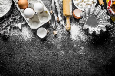 Hamur farklı pişirme formları ile un. Siyah rustik arka plan üzerinde