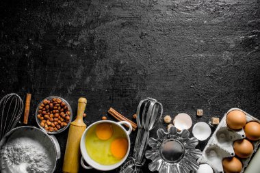 Pişirme arka plan. Ev yapımı kurabiye yapmak için malzemeler. Siyah rustik arka plan üzerinde