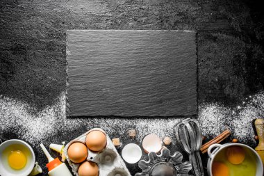 Pişirme arka plan. Ev yapımı kurabiye yapmak için malzemeler. Siyah rustik arka plan üzerinde