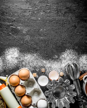 Hamur pişirme için formları ile Yumurta. Siyah rustik arka plan üzerinde