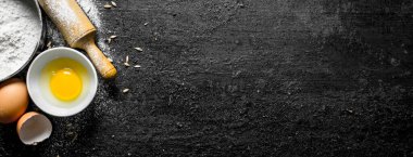 Kaselerde yumurta ile un. Siyah rustik arka plan üzerinde