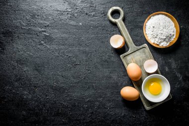 Un ve taze yumurta. Siyah rustik arka plan üzerinde