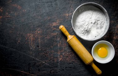 Oklava ve yumurta yıkın. Koyu rustik arka plan üzerinde