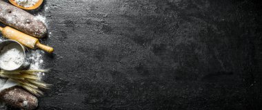 Un, oklava ve sivri ile kokulu çavdar ekmeği. Siyah rustik arka plan üzerinde