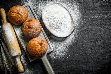 Kase un ile bir kesme Tahtası üzerinde Kabuklu çörekler. Siyah rustik arka plan üzerinde