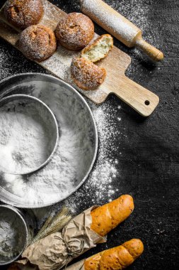 Fransız baget ve un ile taze çörekler. Siyah rustik arka plan üzerinde