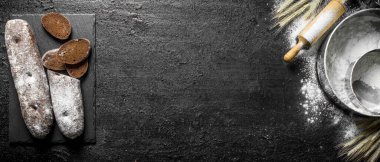 Un ve oklava ile çavdar ekmeği. Siyah rustik arka plan üzerinde