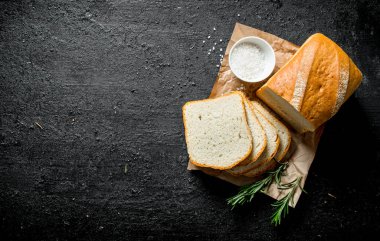 Tuz ve biberiye ile kokulu ekmek parçaları. Siyah rustik arka plan üzerinde