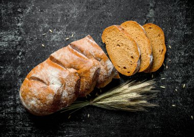 Sivri uçlu dilimlenmiş çavdar ekmeği. Siyah rustik arka plan üzerinde