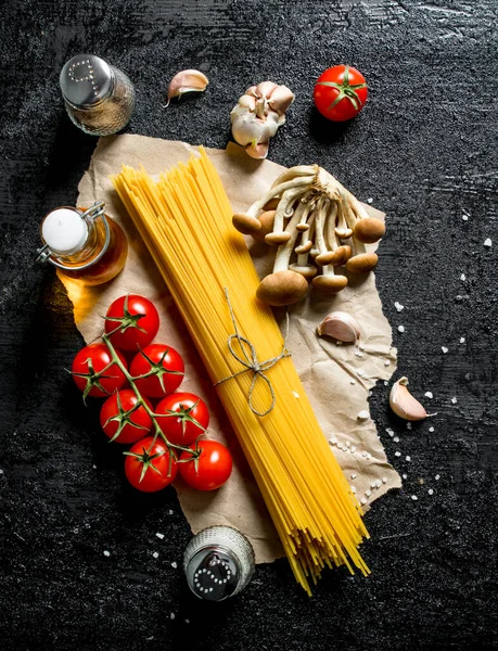 キノコ スパイス トマトをブランチに入れた生スパゲッティ 黒い素朴な背景に — ストック写真