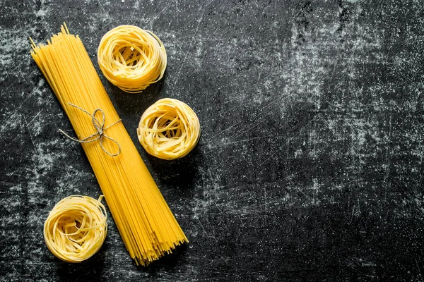Tagliatelle Spaghetti Surowe Czarnym Tle Rustykalnym — Zdjęcie stockowe
