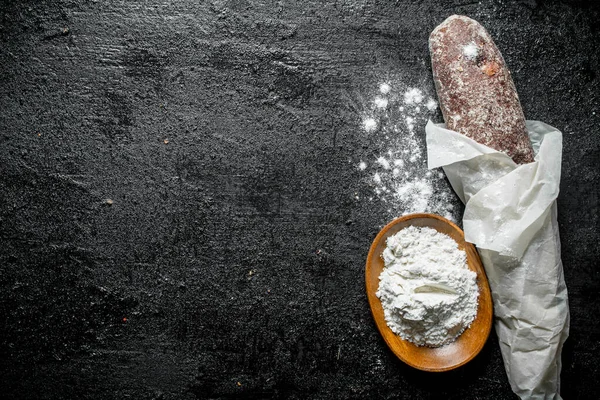 stock image Fresh bread and flour. On black rustic background