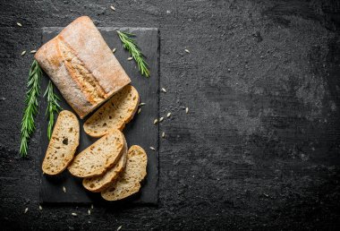 Biberiyeli ekmek parçaları ciabatta. Siyah rustik arka plan üzerinde