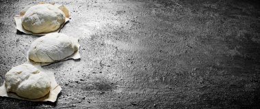 Kağıt üzerinde hamur parçaları. Siyah rustik arka plan üzerinde