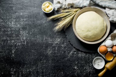 Hamur ve malzemeyi hamur hazırlamak için. Koyu rustik arka plan üzerinde