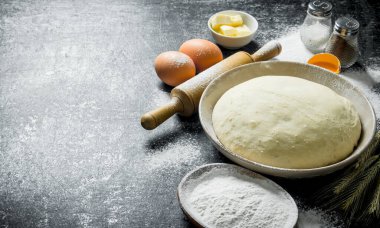 Oklava ve yumurta ile hamur. Koyu rustik arka plan üzerinde