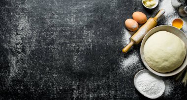 Un, yumurta ve tereyağı ile kasede Hamur. Koyu rustik arka plan üzerinde