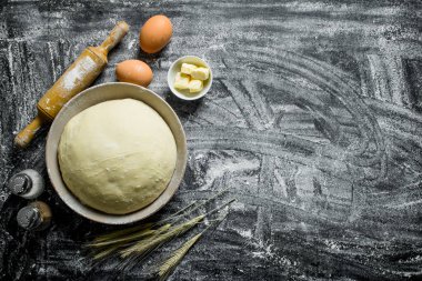 Un arka plan. Yumurta, baharat ve tereyağı parçaları ile Hamur. Rustik arka planda