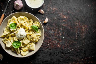 Ekşi krema ve ıspanak ile bir tabak tabaktabak üzerinde Köfte. Koyu rustik arka plan üzerinde