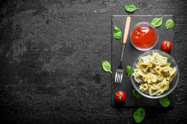 Domates salçası ve ıspanak ile Köfte. Siyah rustik arka plan üzerinde