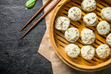 Bambu vapurunda taze pişmiş manta köftesi. Koyu rustik arka plan üzerinde
