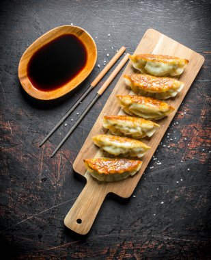 Soya soslu taze pişmiş köfte gedza. Koyu rustik arka plan üzerinde