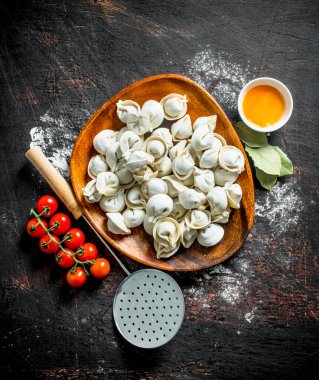 Yumurta sarısı ve kiraz domates ile bir tabakta çiğ köfte. Koyu rustik arka plan üzerinde