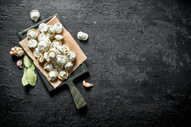 Sarımsak karanfil ve Defne yaprağı ile ev yapımı çiğ köfte. Siyah rustik arka plan üzerinde