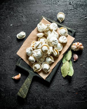 Sarımsak karanfil ve Defne yaprağı ile ev yapımı çiğ köfte. Siyah rustik arka plan üzerinde